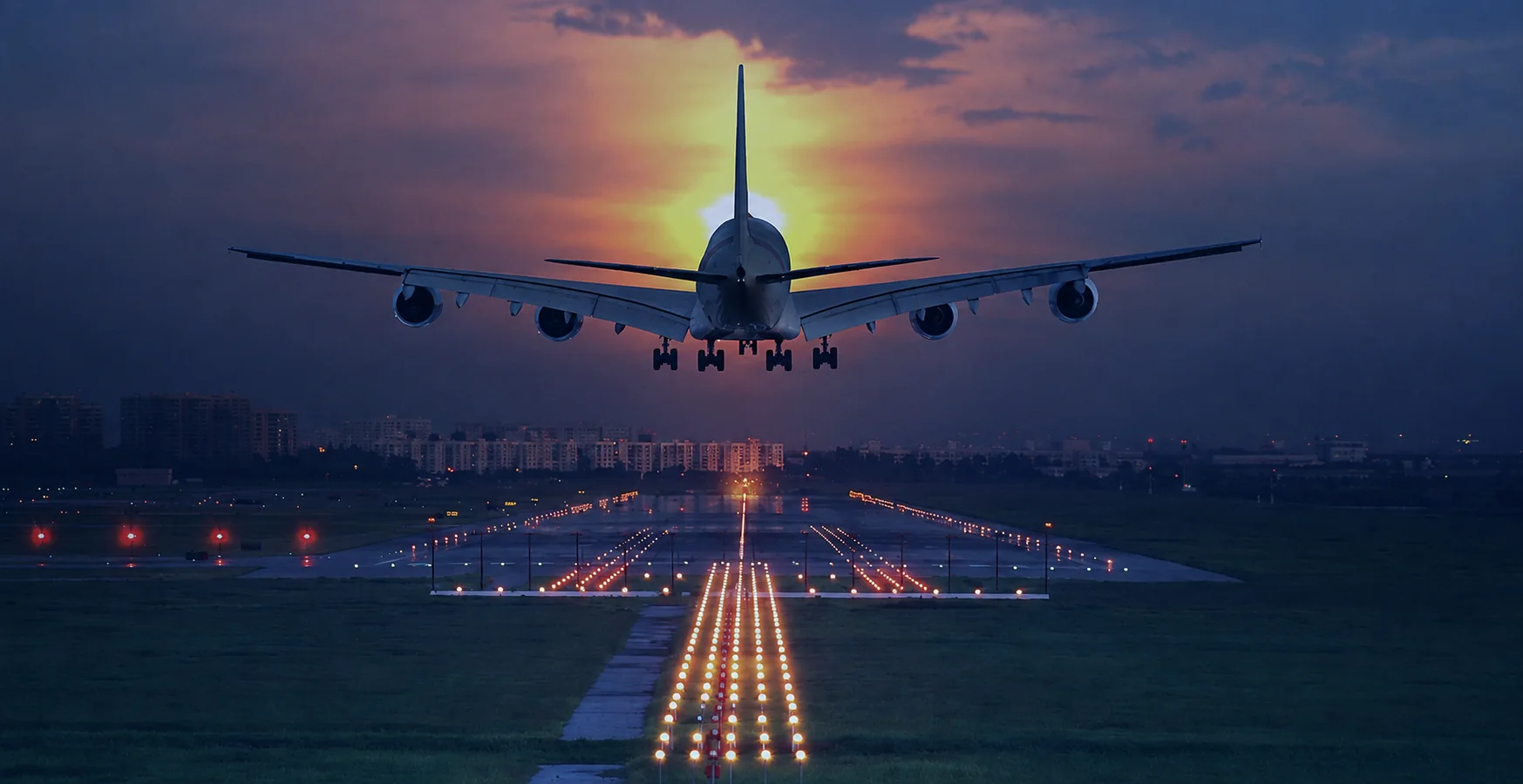 Passenger aircraft approaching an illuminated runway at sunset
